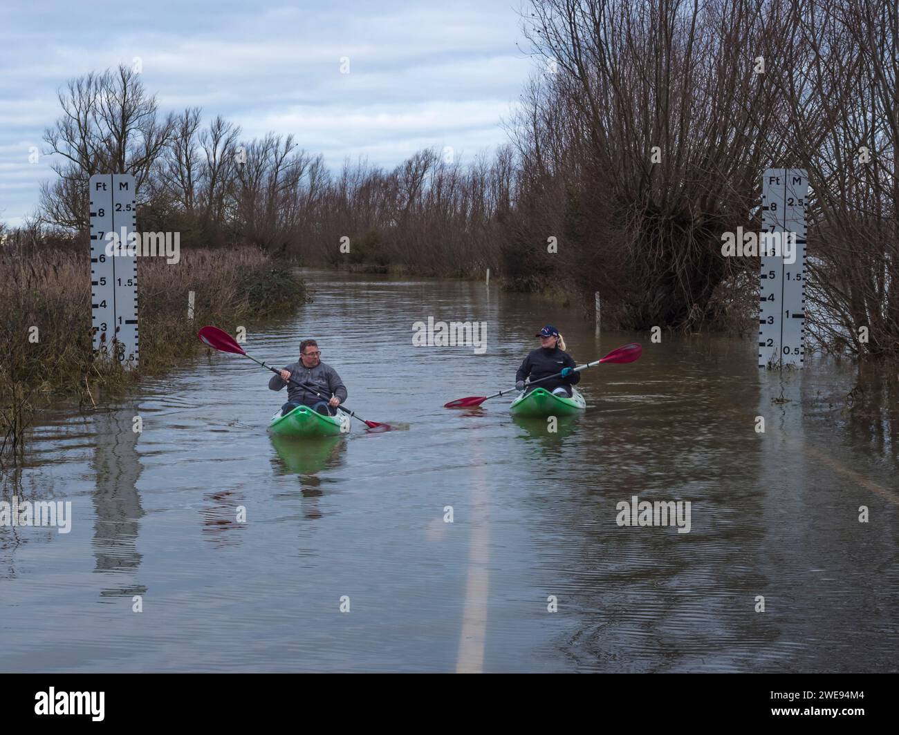 Kanufahrer paddeln auf überfluteten Straßen in Welney Wash, Norfolk, England Stockfoto