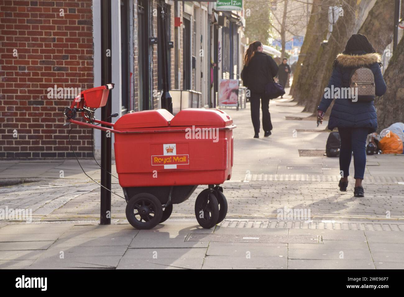 London, Großbritannien. Januar 2024. Menschen gehen an einem geparkten Postzustellwagen in Zentral-London vorbei, da die britische Regulierungsbehörde Ofcom vorschlägt, dass Royal Mail die Lieferungen auf drei Tage pro Woche reduziert. Quelle: Vuk Valcic/Alamy Live News Stockfoto