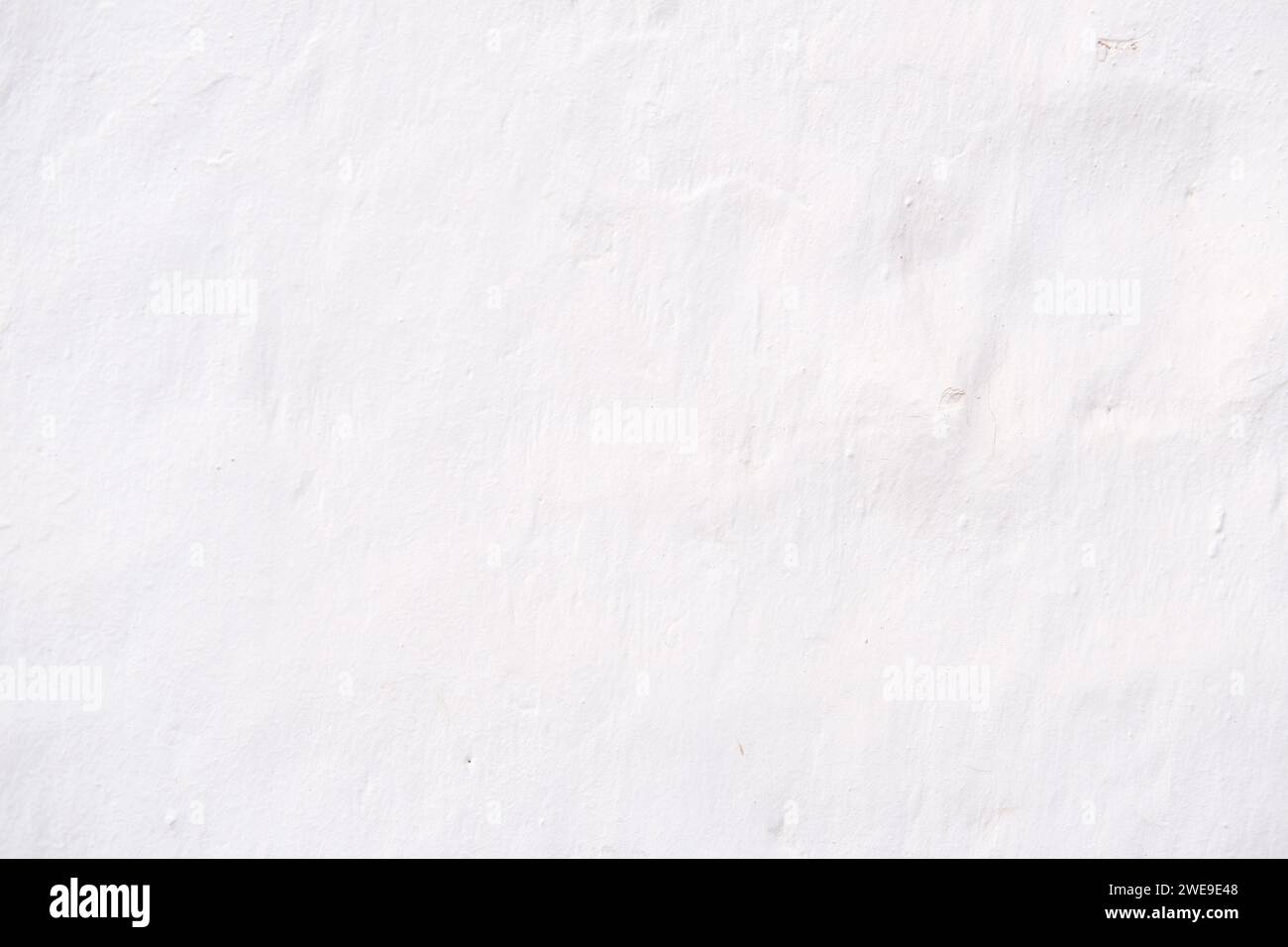 Rustikale weiße Wand als Hintergrund für Designarbeiten. Stockfoto