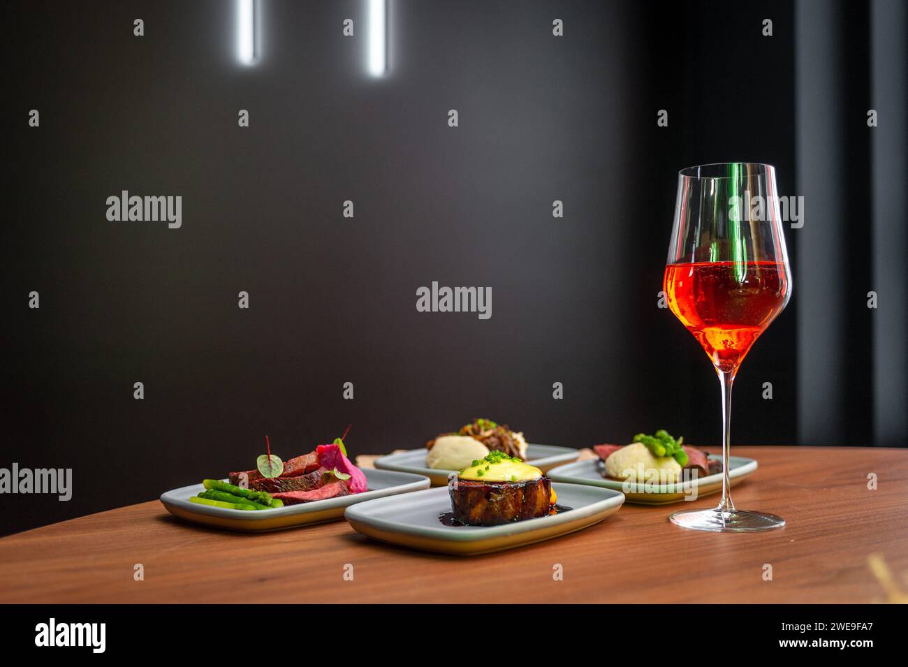 Eine Auswahl an Gerichten auf einem Tisch in einem Restaurant mit einem Glas Wein. Stockfoto
