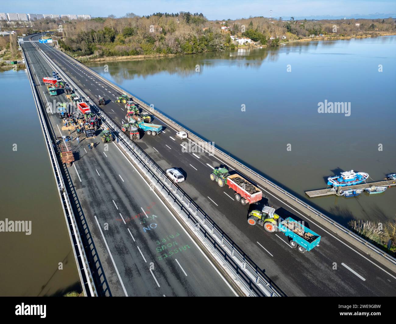 Demonstration von Landwirten, die die Autobahn A63 blockieren (Viaduc Hubert Touya, Bayonne (64100), Pyrénées-Atlantiques (64), Nouvelle Aquitaine, Frankreich). An diesem Dienstag, dem 23. Januar 2024, haben die Bauern der Pyrénées-Atlantiques, auf Aufforderung der FDSEA 64 und der Junglandwirte, ab 6 Uhr morgens Sperrpunkte an den Autobahnkreuzen Bayonne organisiert. Der Verkehr wird diesen Dienstag auf diesem Teil der Autobahn von entschlossenen Demonstranten unterbrochen. Die Landwirtschaftsdemonstrationen sind ein Zeichen der Krise, vor der der Agrarsektor in Frankreich und Europa steht. Stockfoto