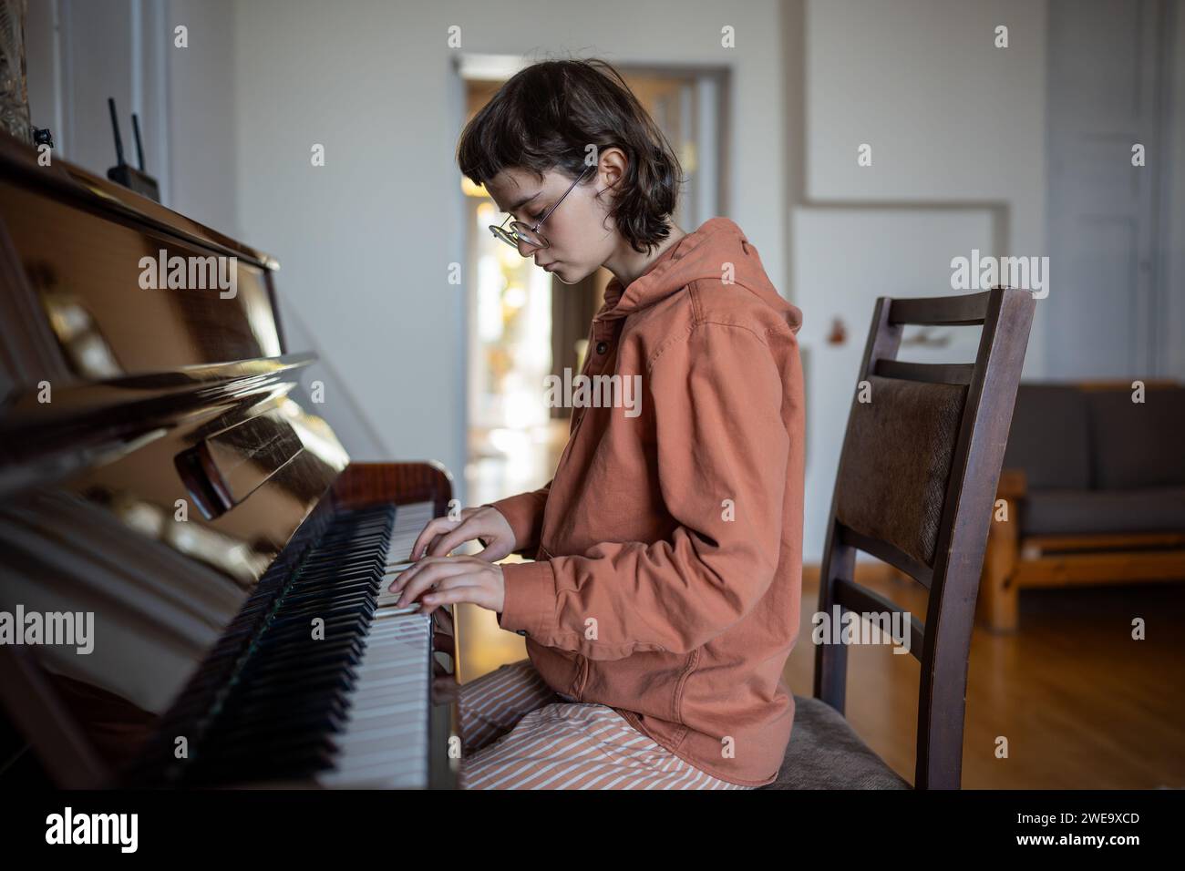Teen Girl Pianistin berührt Klaviertasten, spielt klassische Musik, übt Fertigkeiten zu Hause Stockfoto