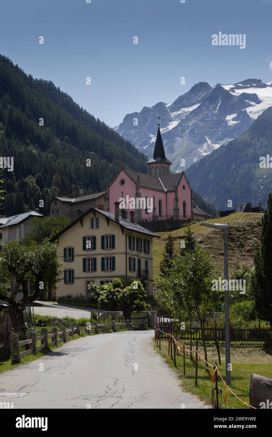 Blick auf das Dorf Trient und die pinkfarbene Kirche in Martigny, Wallis in der Schweiz. Mit wunderschönen Bergen im Hintergrund. Es ist ein beliebtes Touristenziel Stockfoto