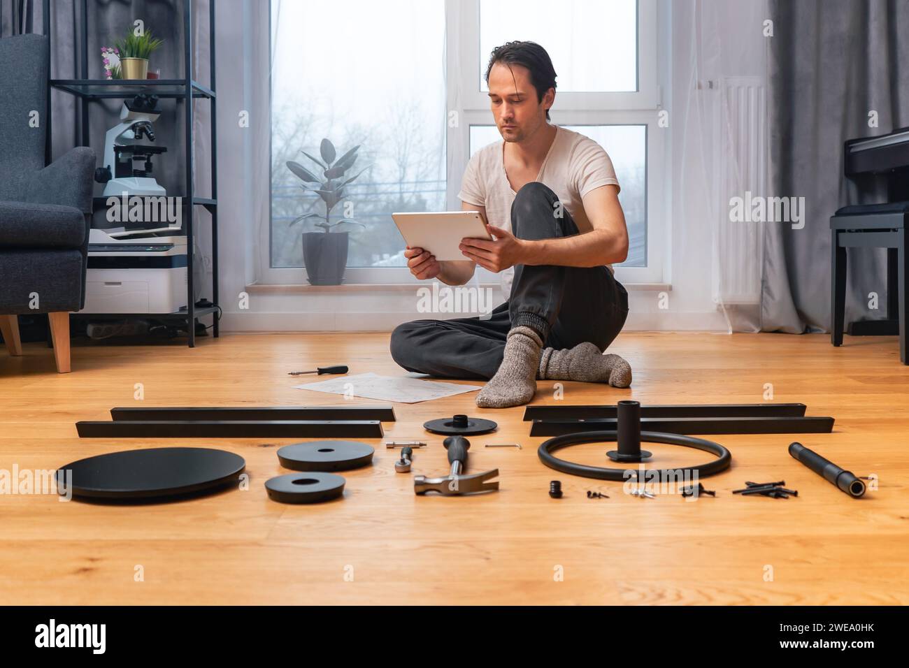 Ein Mann erhält per Video-Link technischen Support für die Montage von Möbeln aus der Ferne. Stockfoto