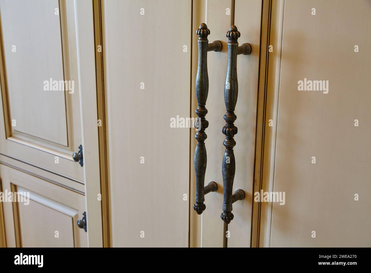 Elegante antike Türgriffe an cremefarbenen Doppeltüren Stockfoto