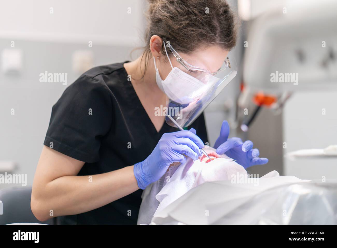 Der Zahnarzt untersucht Mund und Zähne des Patienten mit einem Zahnforscher. Stockfoto