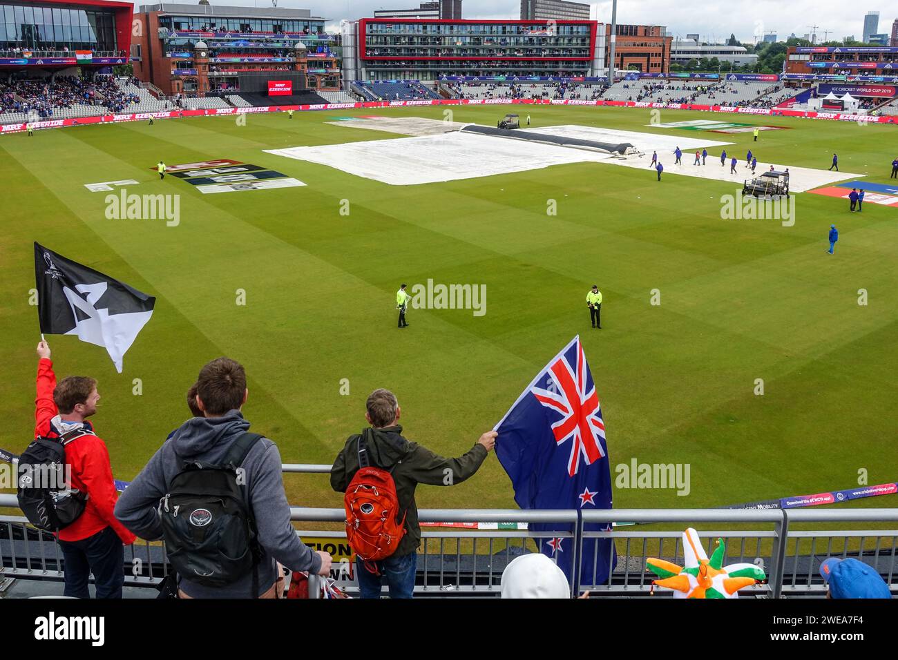 Zuschauer mit Fahnen sehen ein Cricket-Spiel (Neuseeland - Indien, Halbfinale) im Old Trafford Stadion an einem bewölkten Tag bei der Cricket-Weltmeisterschaft 2019 Stockfoto