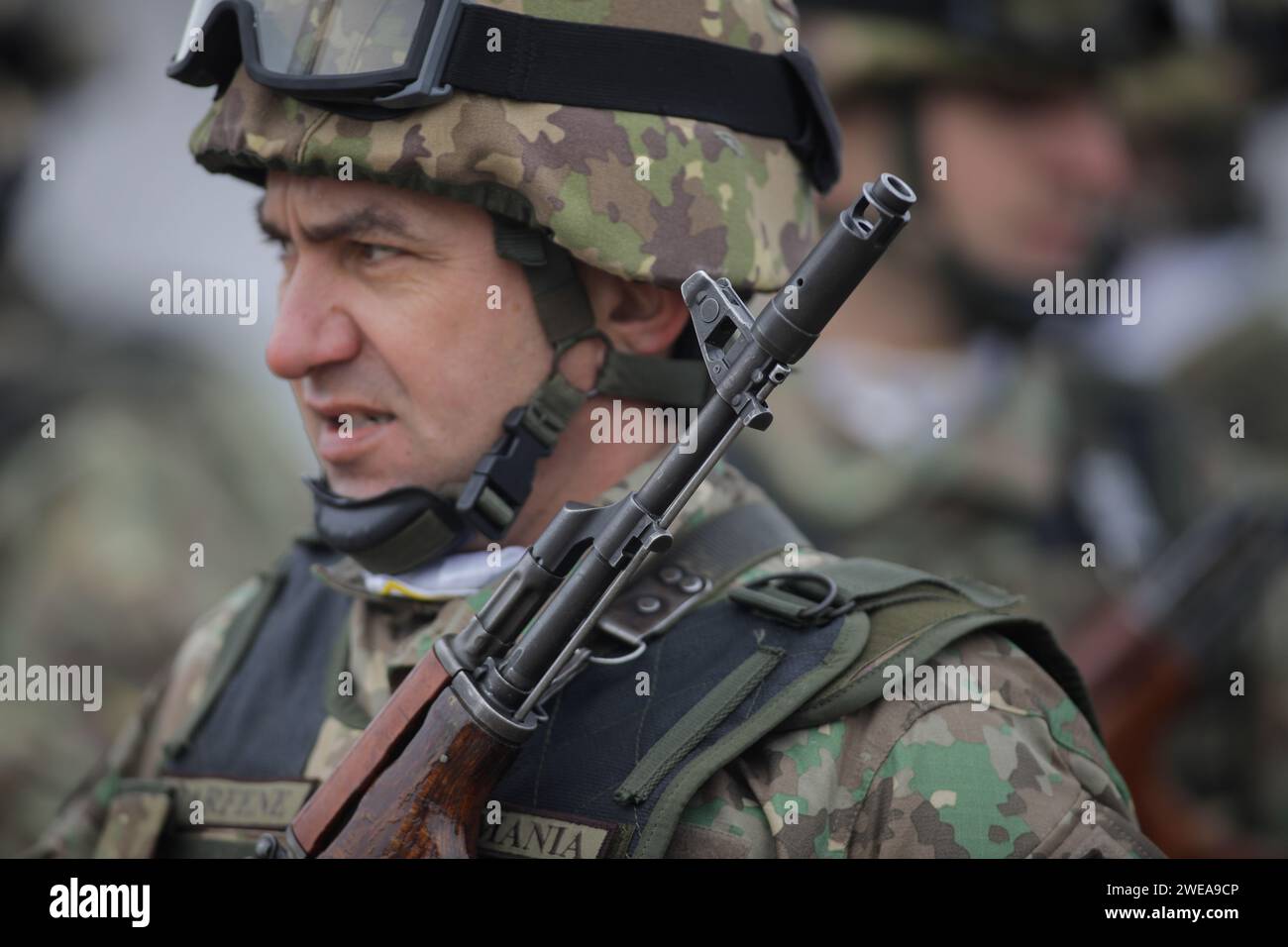 Bukarest, Rumänien - 24. Januar 2024: Details mit einem rumänischen Armeesoldaten, der während einer militärischen Zeremonie am Monument ein AK 47-Sturmgewehr hält Stockfoto