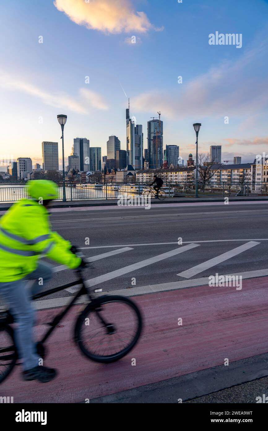 Skyline der Innenstadt von Frankfurt am Main, Radfahrer auf der Ignatz Bubis Brücke, Dämmerung, Main, Winter, Hessen, Deutschland Stockfoto