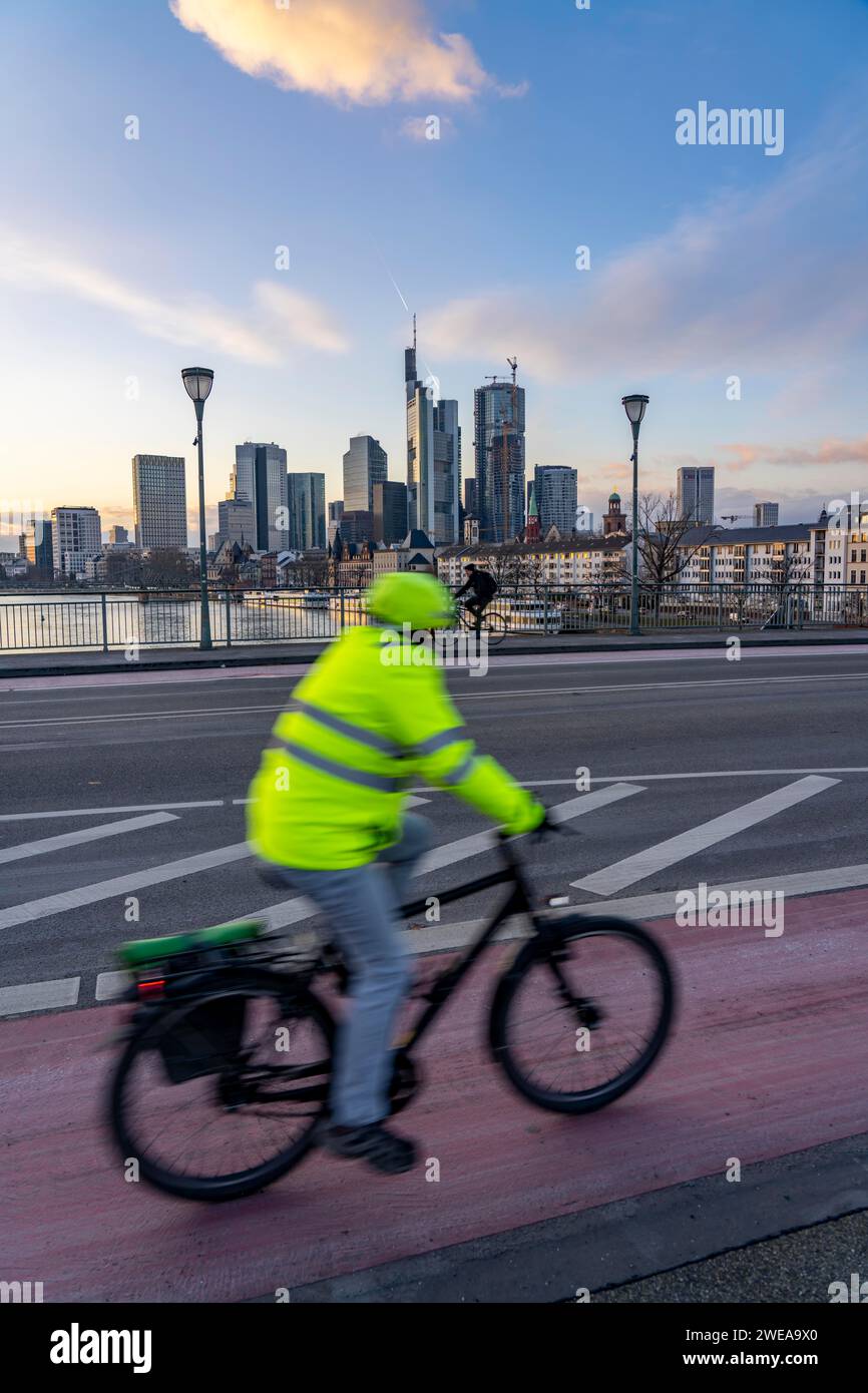 Skyline der Innenstadt von Frankfurt am Main, Radfahrer auf der Ignatz Bubis Brücke, Dämmerung, Main, Winter, Hessen, Deutschland Stockfoto