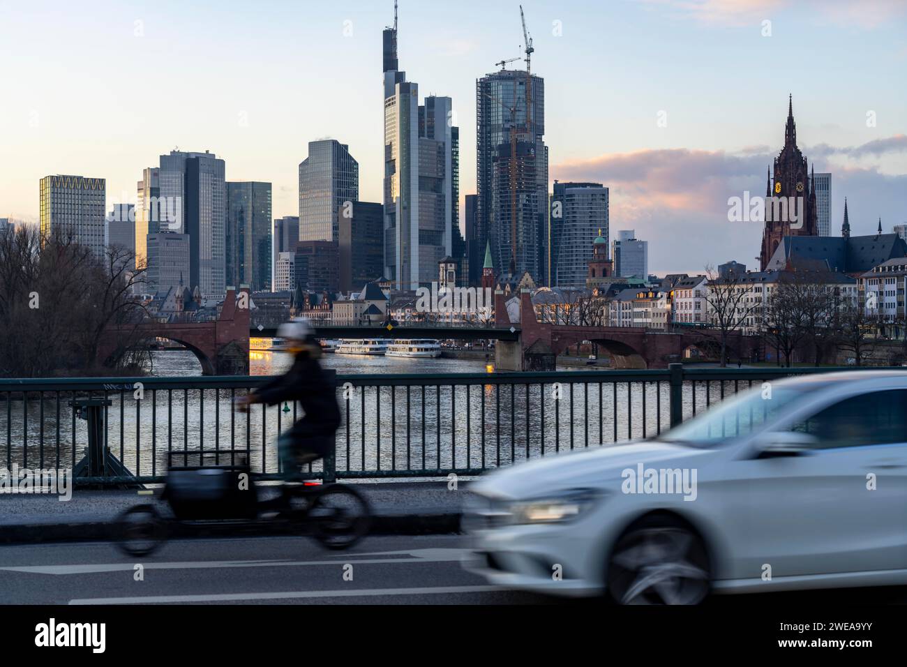 Skyline der Innenstadt von Frankfurt am Main, Lastenradfahrer auf der Ignatz-Bubis-Brücke, Dämmerung, Main, Winter, Hessen, Deutschland Stockfoto