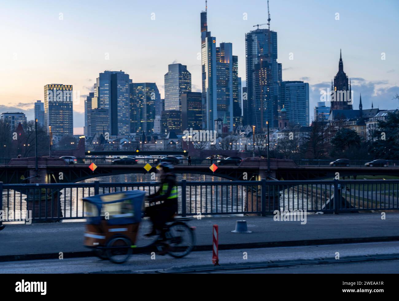 Skyline der Innenstadt von Frankfurt am Main, Lastenradfahrer auf der Sparrenbrücke, Dämmerung, Main, Winter, Hessen, Deutschland Stockfoto
