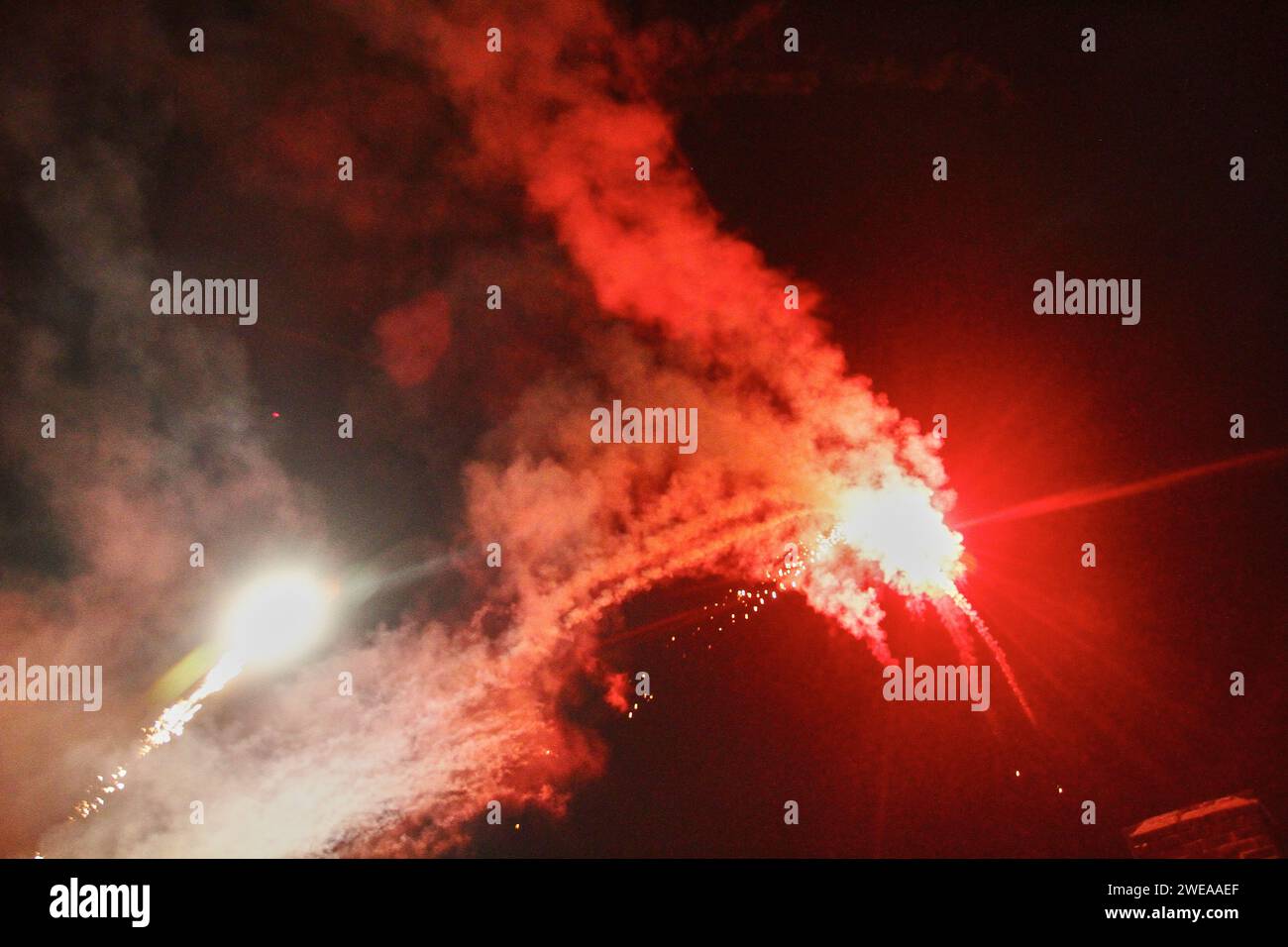 Festliches Feuerwerk mit Stadtglühen und Bodenperspektive Stockfoto