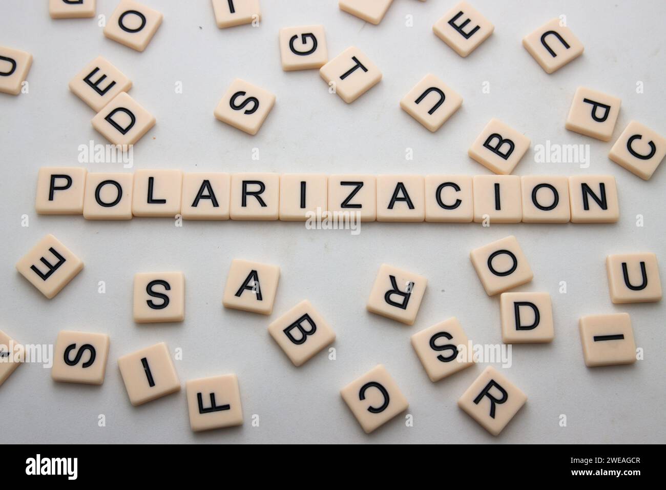 Bild des Wortes Polarisation, Wort des Jahres 2023 in Spanien von Fundeu erklärt, umgeben von Ziegeln mit Buchstaben und auf einem weißen Tisch Stockfoto