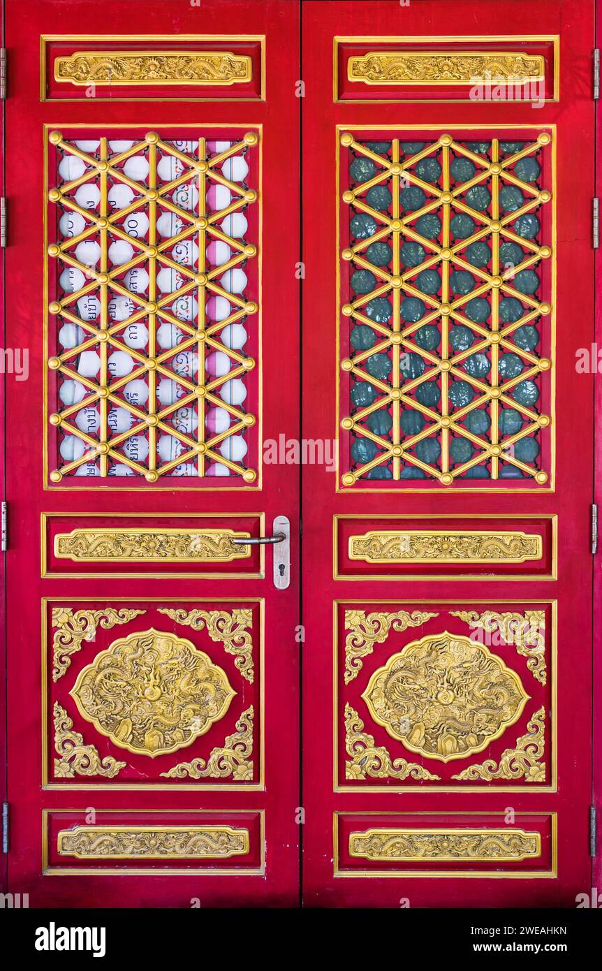 Alte chinesische rote Holztür mit goldenem Drachenschnitzertor des chinesischen Tempels Stockfoto