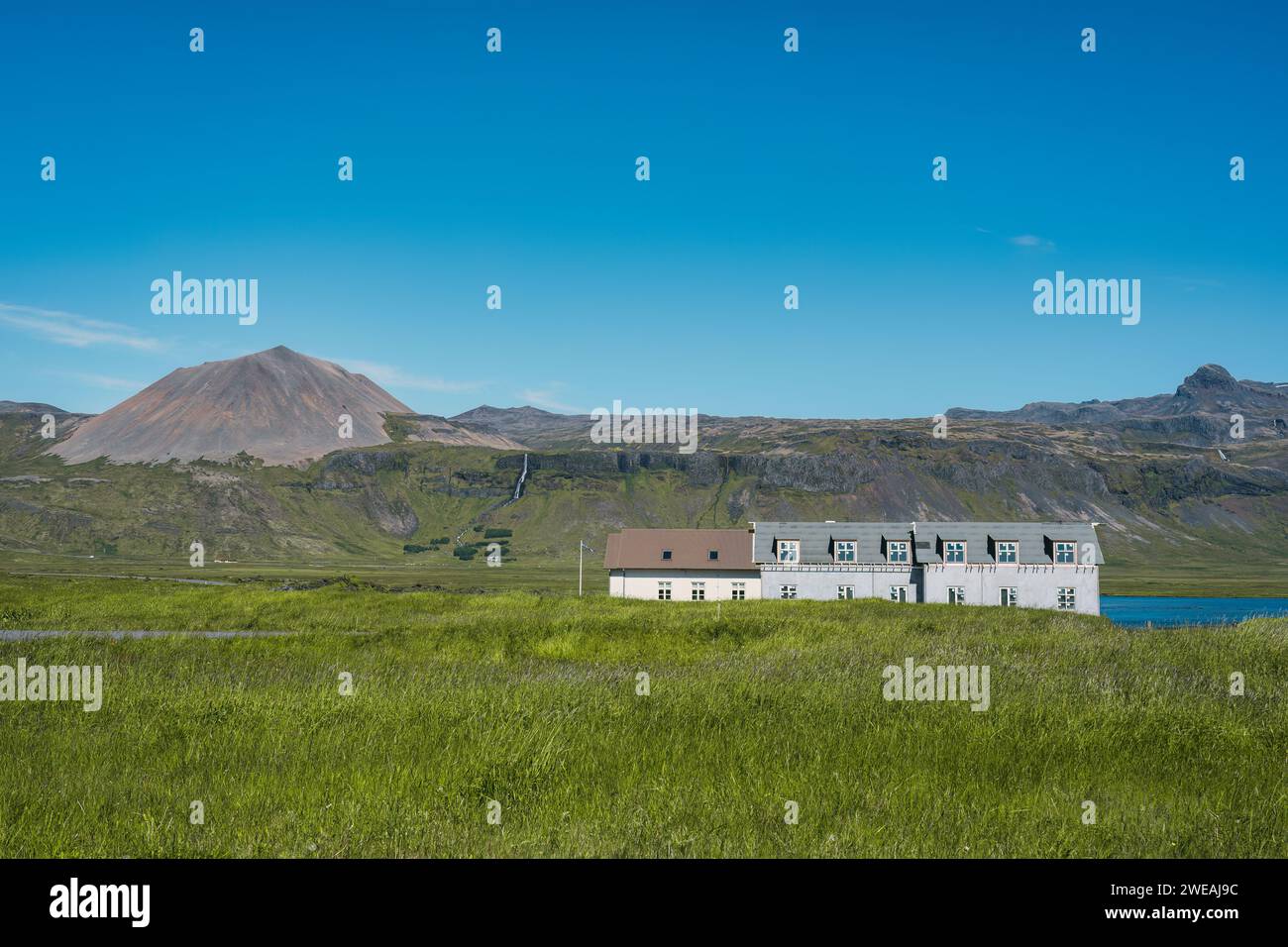 Skandinavisches Haus auf Wiese und vulkanischem Berggrund im Sommer in Island Stockfoto