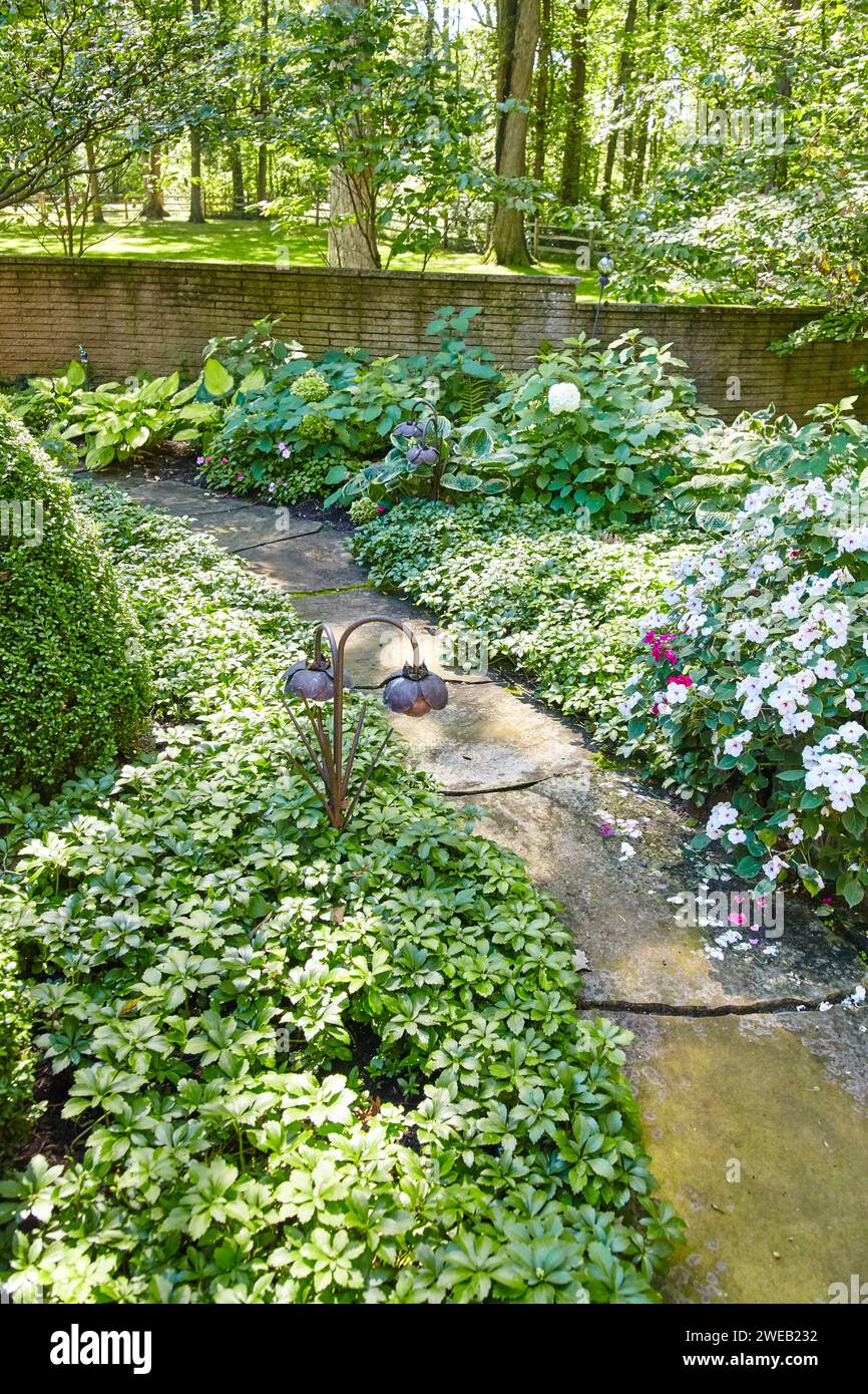 Ruhiger Gartenpfad mit üppigem Grün und Ornament, Blick auf Augenhöhe Stockfoto