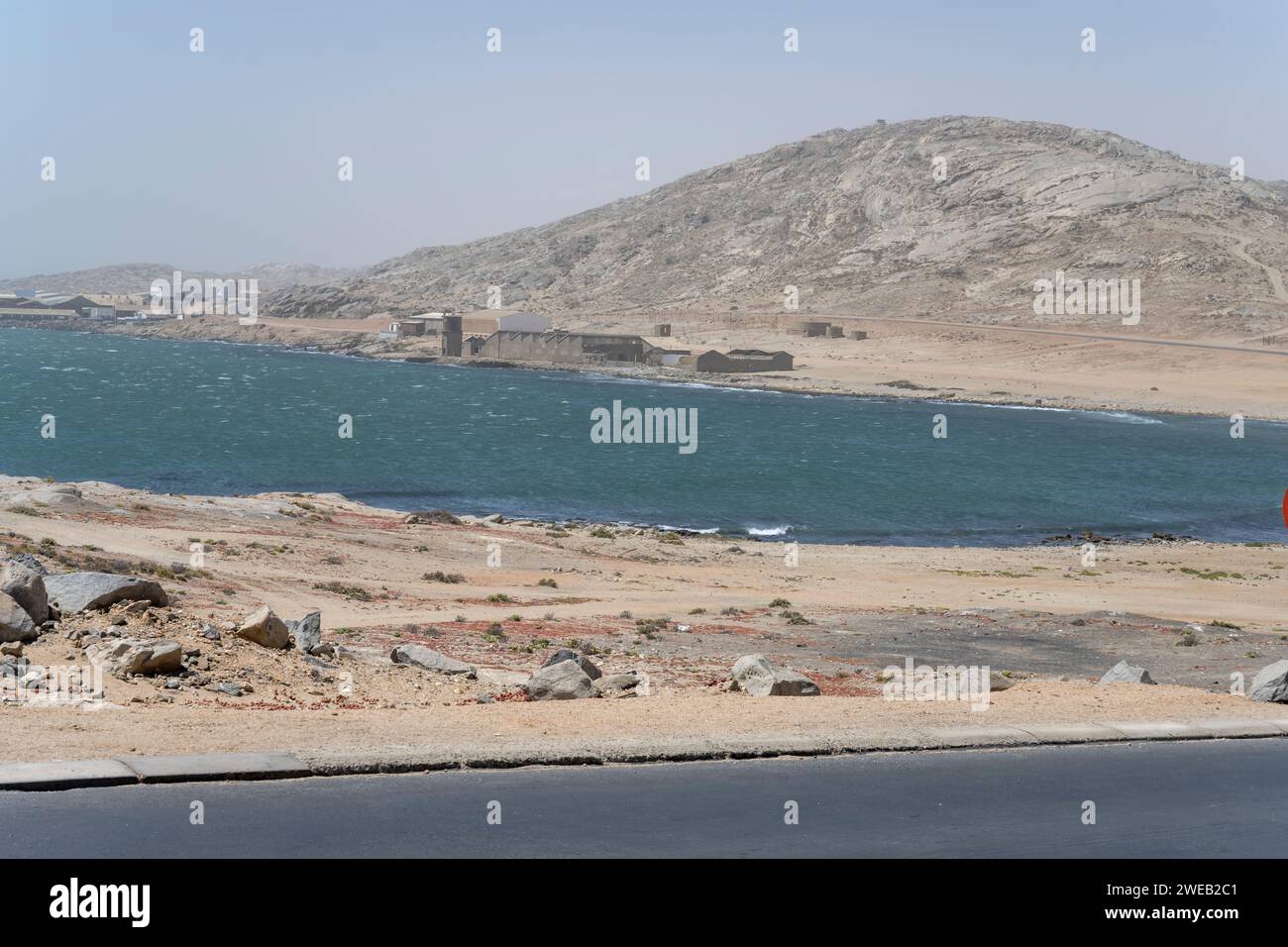 Stadtlandschaft mit heruntergekommenen Industriebauten am Strand von Agate, aufgenommen im hellen Licht des späten Frühlings in Luderitz, Namibia, Afrika Stockfoto