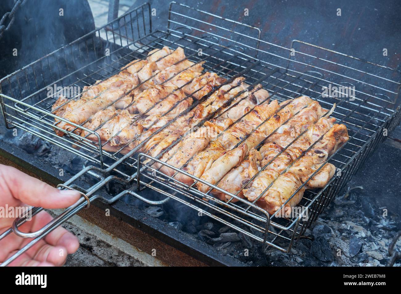 Geröstete Fleischscheiben auf einem Grill, über dem Feuer gegrillt. Hühnerfleisch wird auf Grillrost gekocht. Nahaufnahme. Stockfoto