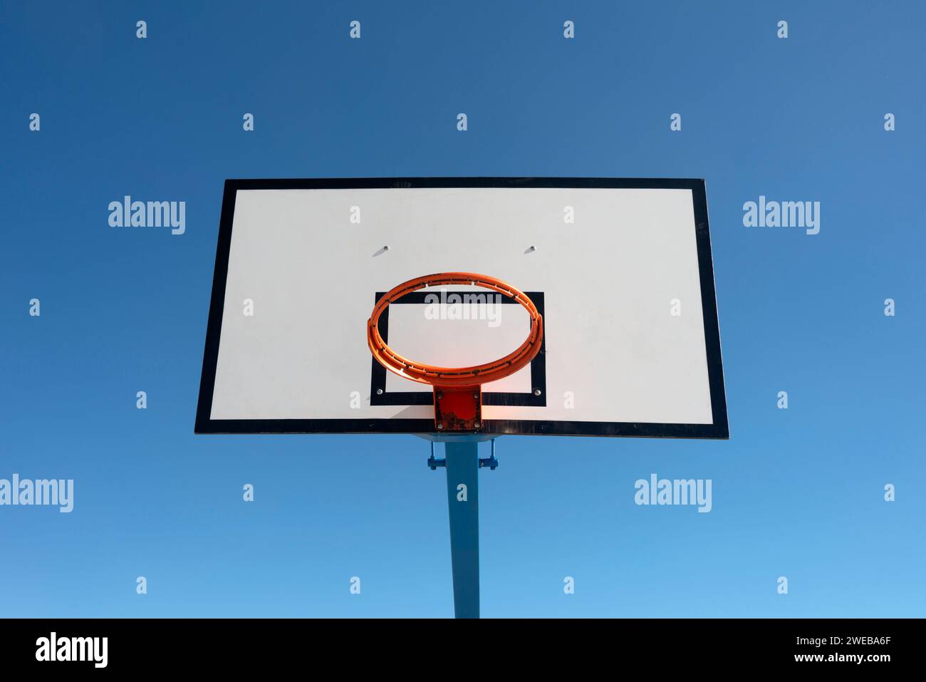 Basketballkorb und Rückenbrett vor einem klaren blauen Himmel Stockfoto