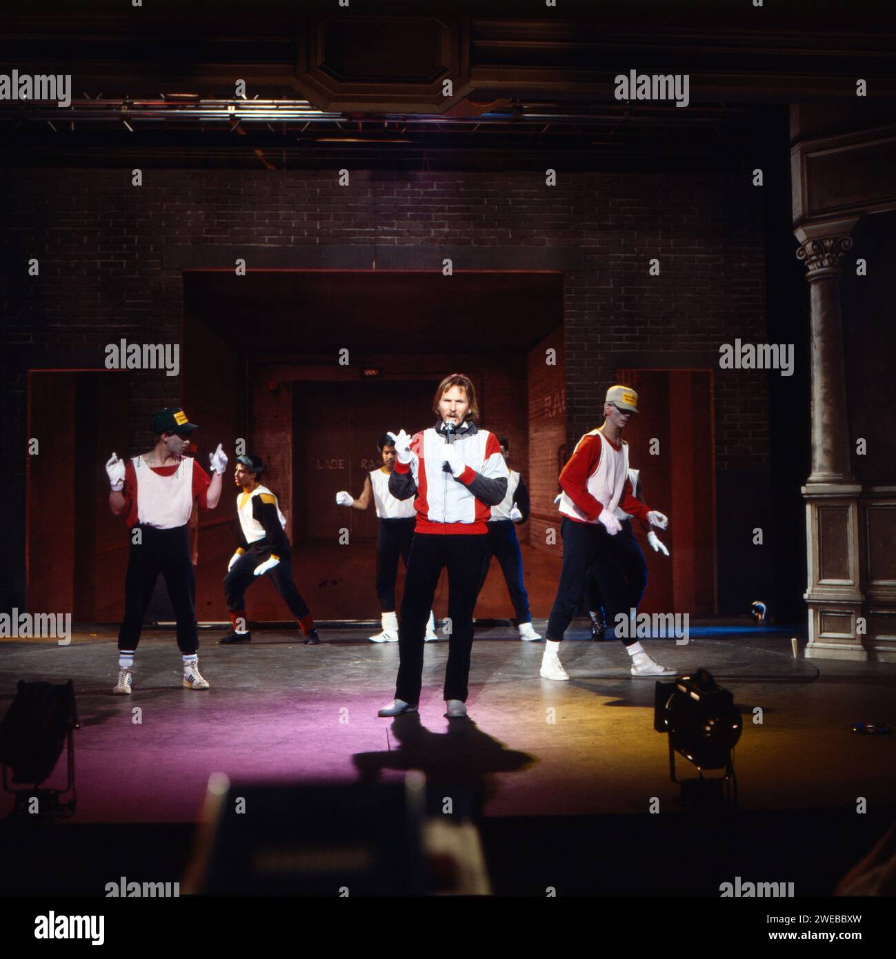Frank Zander, deutscher Schlager- und Deutschpop-Musiker, Moderator und Schauspieler, bei einem Auftritt mit Breakdance Gruppe, Deutschland um 1982. Stockfoto