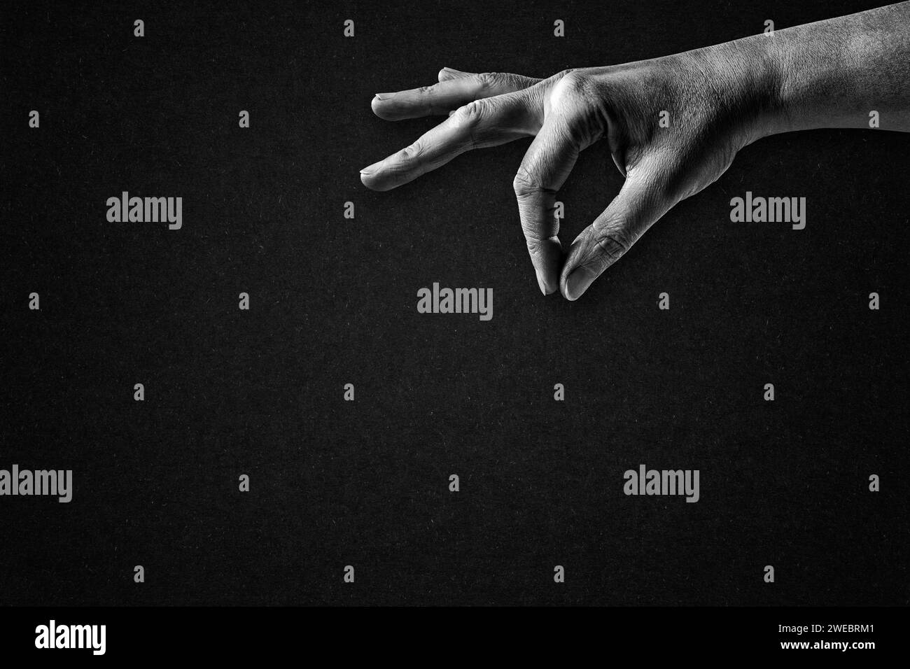 Hand Sprinkle Halten etwas Zeichen in Schwarz-weiß auf strukturiertem Papier Hintergrund, Kopierraum Stockfoto