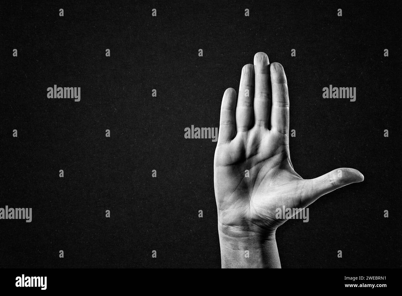 Hand Gestenstopp Zeichen in Schwarzweiß auf strukturiertem Papierhintergrund, Kopierraum Stockfoto