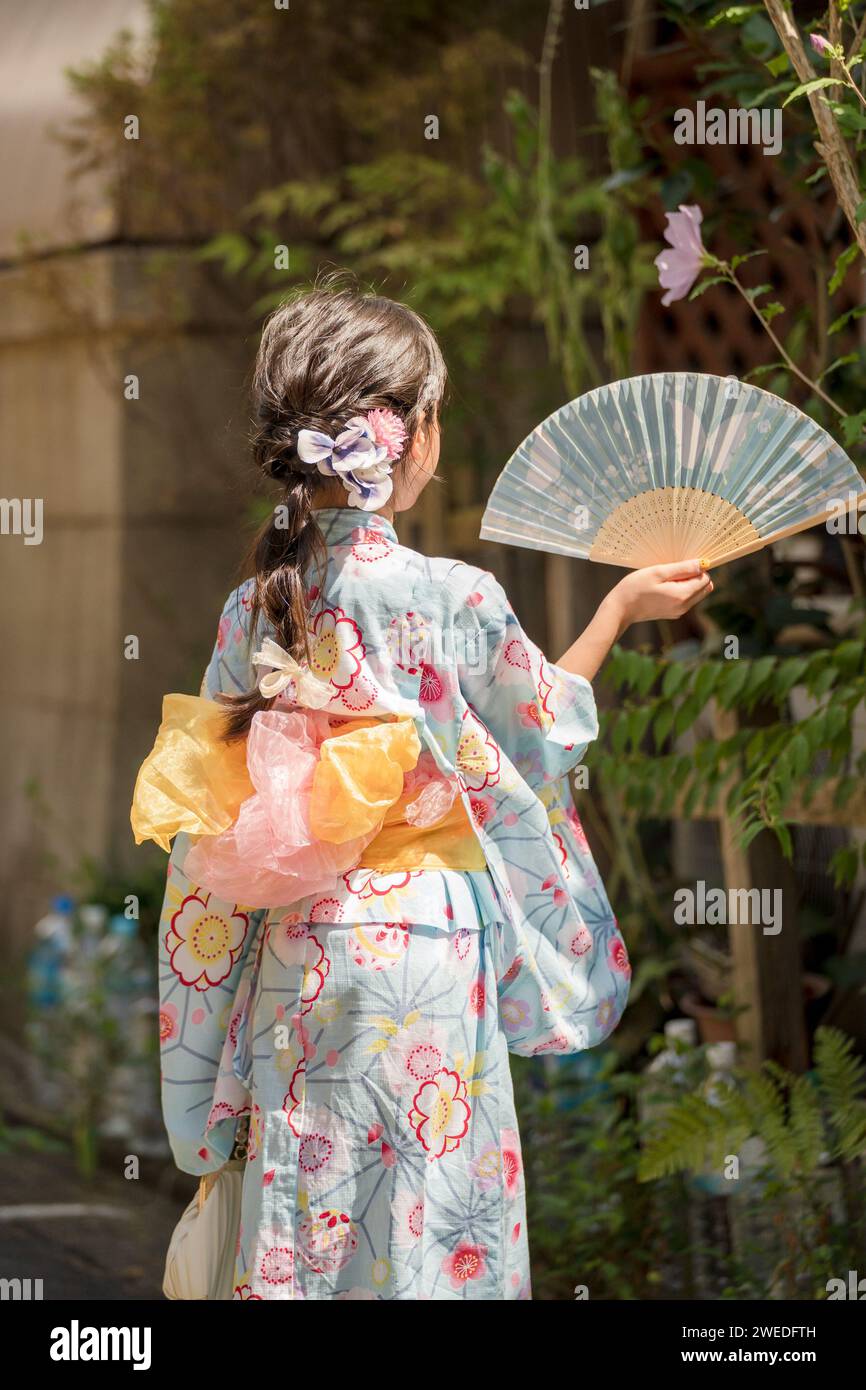 Mädchen mit Kimono Yukata und einem Ventilator im Garten in Kyoto, Japan. Stockfoto