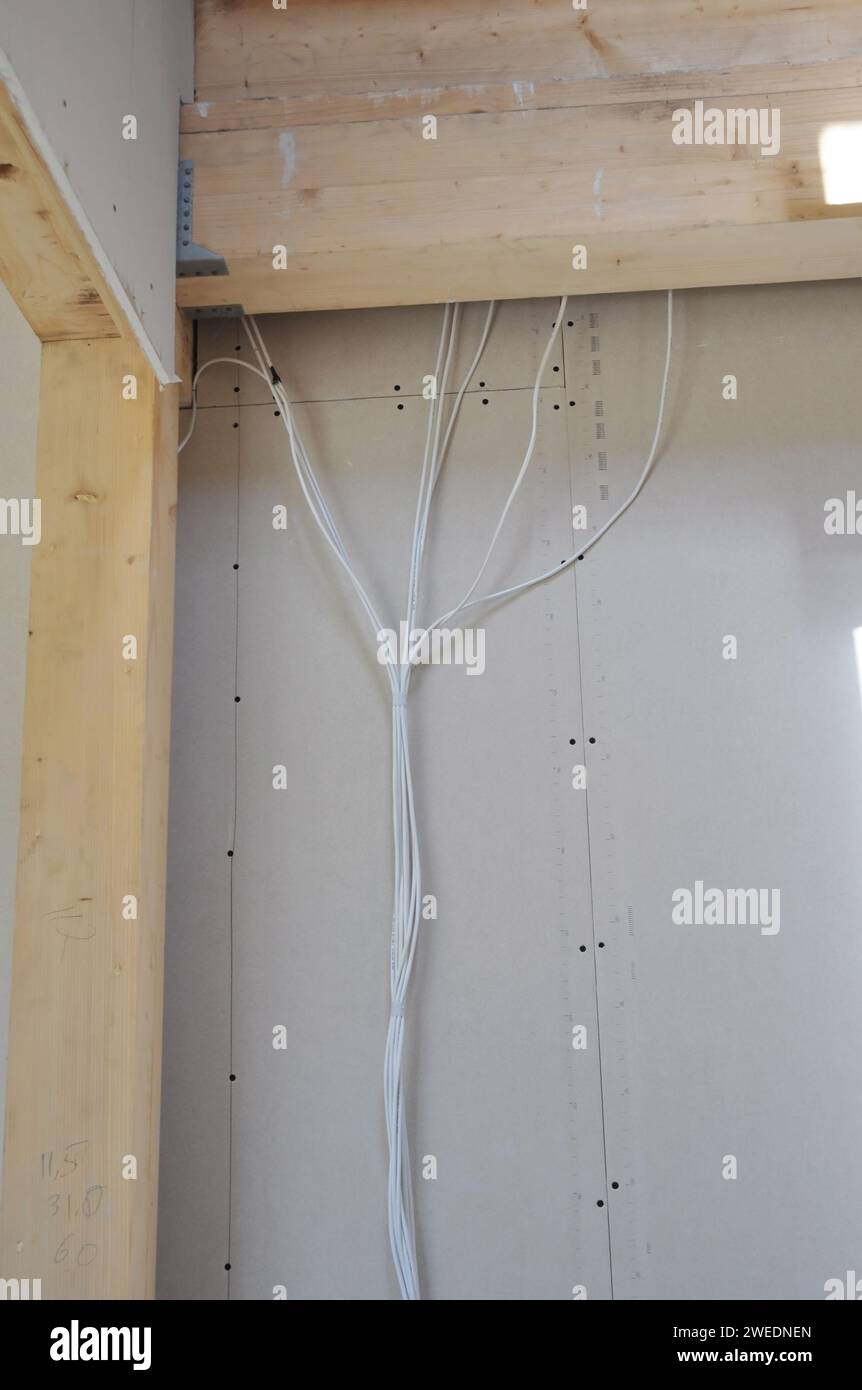 Eine Nahaufnahme einer elektrischen Verkabelung in einem Rahmenhaus. Verdeckung von Elektrokabeln in Wänden während der Renovierung des Hauses Stockfoto