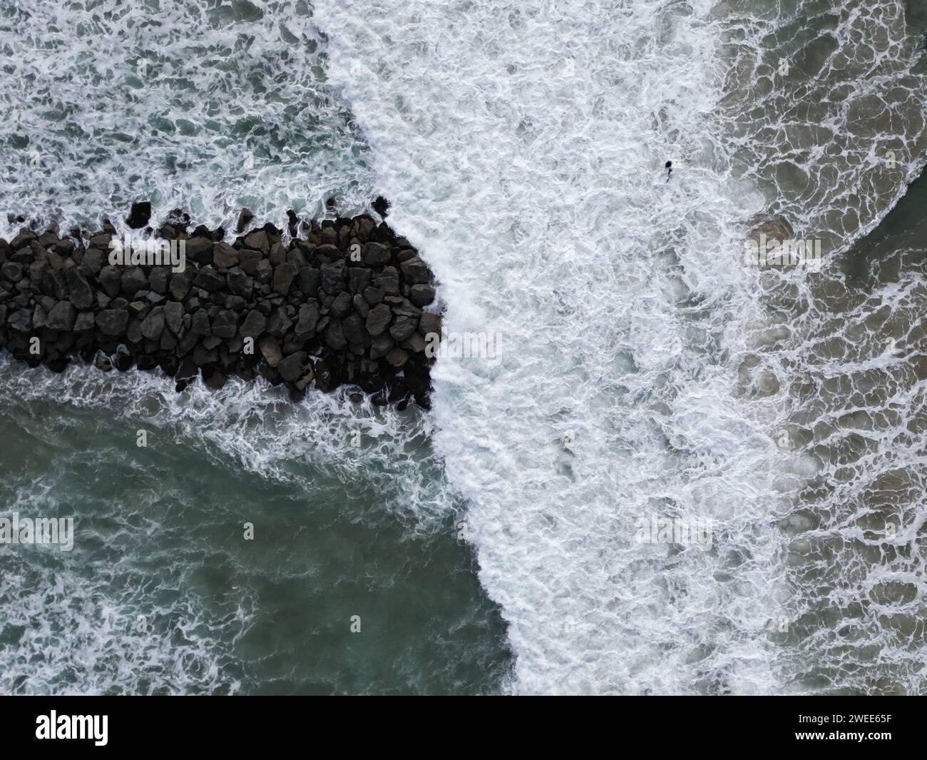 Ein hochauflösendes Luftbild von Wellen, die auf Felsen am Strand treffen Stockfoto