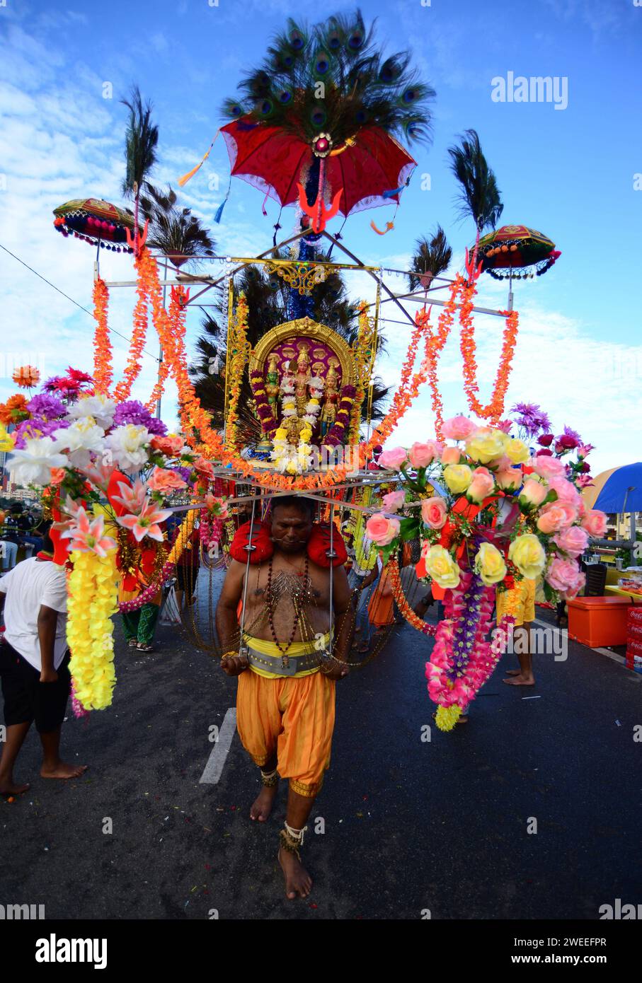 KUALA LUMPUR 25/01/2024 Thaipusam oder Thaipoosam ist ein Tamil-Hindu-Festival, das am ersten Vollmondtag des tamilischen Monats Thai gefeiert wird und mit dem Pusam-Stern zusammenfällt. Das Festival wird gefeiert, um dem Sieg des hinduistischen Gottes Murugan über den Dämon Surapadman zu gedenken. Das Festival umfasst rituelle Praktiken von Kavadi Aattam, ein zeremonieller Akt des Opfers, der eine physische Belastung trägt, um eine spirituelle Schuld auszugleichen. Die Anbeter tragen oft einen Topf Kuhmilch als Opfergabe und mortieren auch das Fleisch, indem sie die Haut und die Zunge durchstechen Stockfoto KUALA LUMPUR 25/01/2024 Thaipusam oder Thaipoosam ist ein Tamil-Hindu-Festival, das am ersten Vollmondtag des tamilischen Monats Thai gefeiert wird und mit dem Pusam-Stern zusammenfällt. Das Festival wird gefeiert, um dem Sieg des hinduistischen Gottes Murugan über den Dämon Surapadman zu gedenken. Das Festival umfasst rituelle Praktiken von Kavadi Aattam, ein zeremonieller Akt des Opfers, der eine physische Belastung trägt, um eine spirituelle Schuld auszugleichen. Die Anbeter tragen oft einen Topf Kuhmilch als Opfergabe und mortieren auch das Fleisch, indem sie die Haut und die Zunge durchstechen Stockfoto