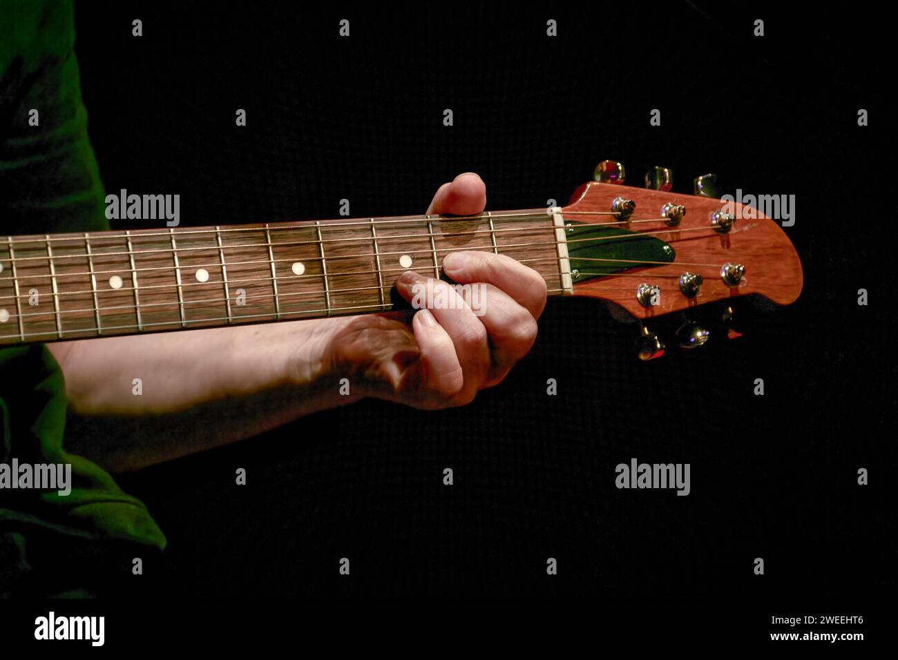 Bild eines Musikers, der einen Akkord am Gitarrenhals spielt Stockfoto