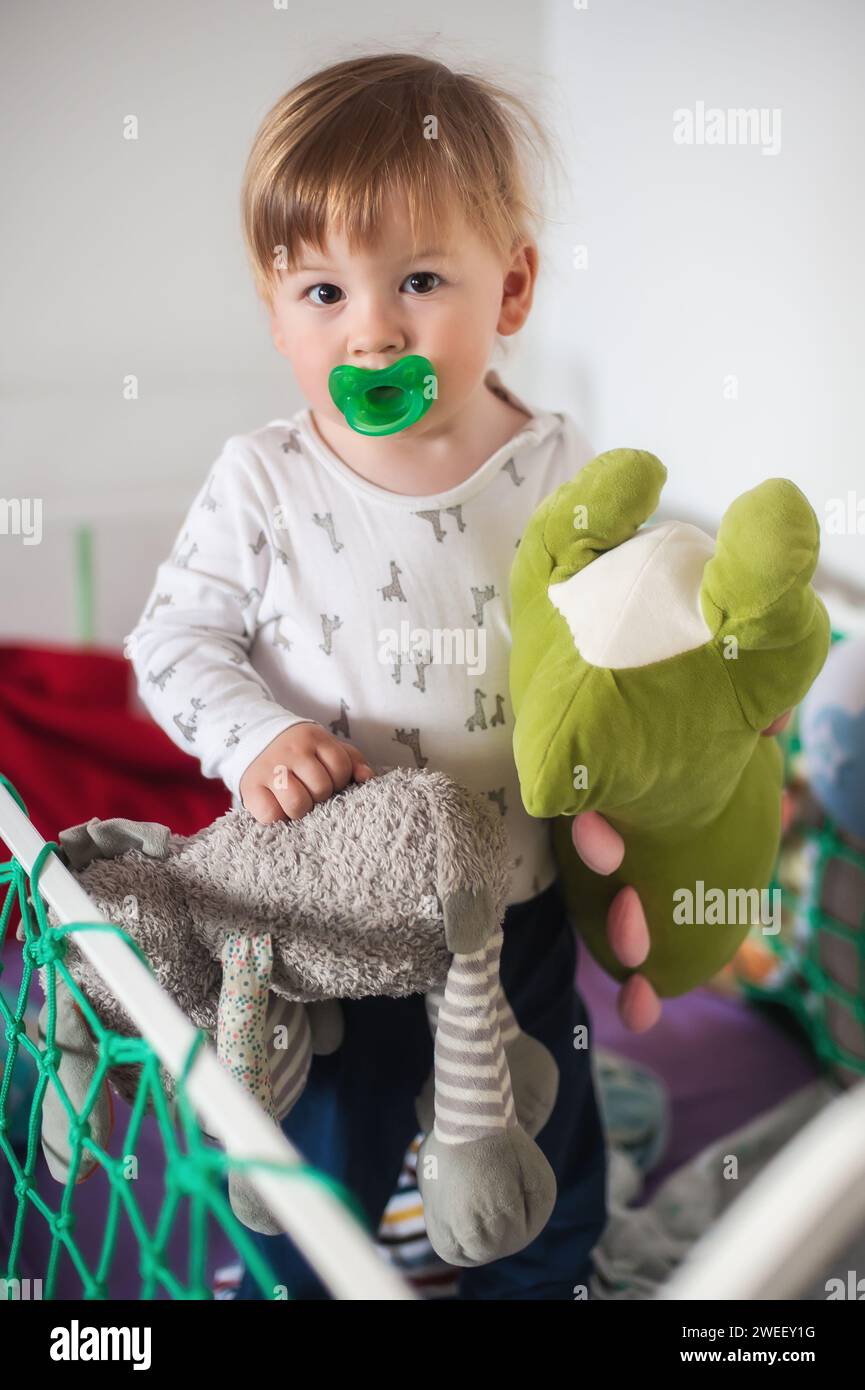 Zärtlicher Moment zwischen einem glücklichen, süßen Jungen und seinen liebsten Kuschelspielzeugen. Untergeordnetes Konzept Stockfoto