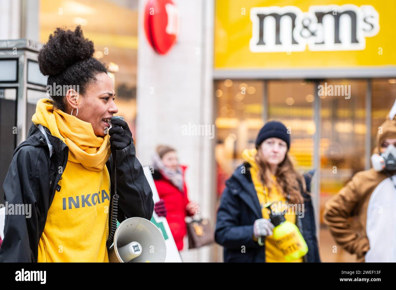 Deutschland, Berlin, 25. Januar 2024: Aktivistinnen und Aktivistinnen protestieren gegen den Einsatz hochgefährlicher Pestizide im Kakaoanbau im Vorfeld der ISM Cologne 2024 vor dem MARS M&M Store Berlin. Die Aktivisten und Unterstützer der Entwicklungsorganisation INKOTA-netzwerk e.V. fordern große Schokoladenunternehmen wie MARS AUF, den Einsatz hochgefährlicher Pestizide in ihren Lieferketten einzustellen, die in Europa aufgrund ihrer schädlichen Auswirkungen nicht zugelassen sind. Sie weisen darauf hin, dass 1,5 Millionen Kinder diesen Pestiziden in Kakaokulturen ausgesetzt sind Stockfoto