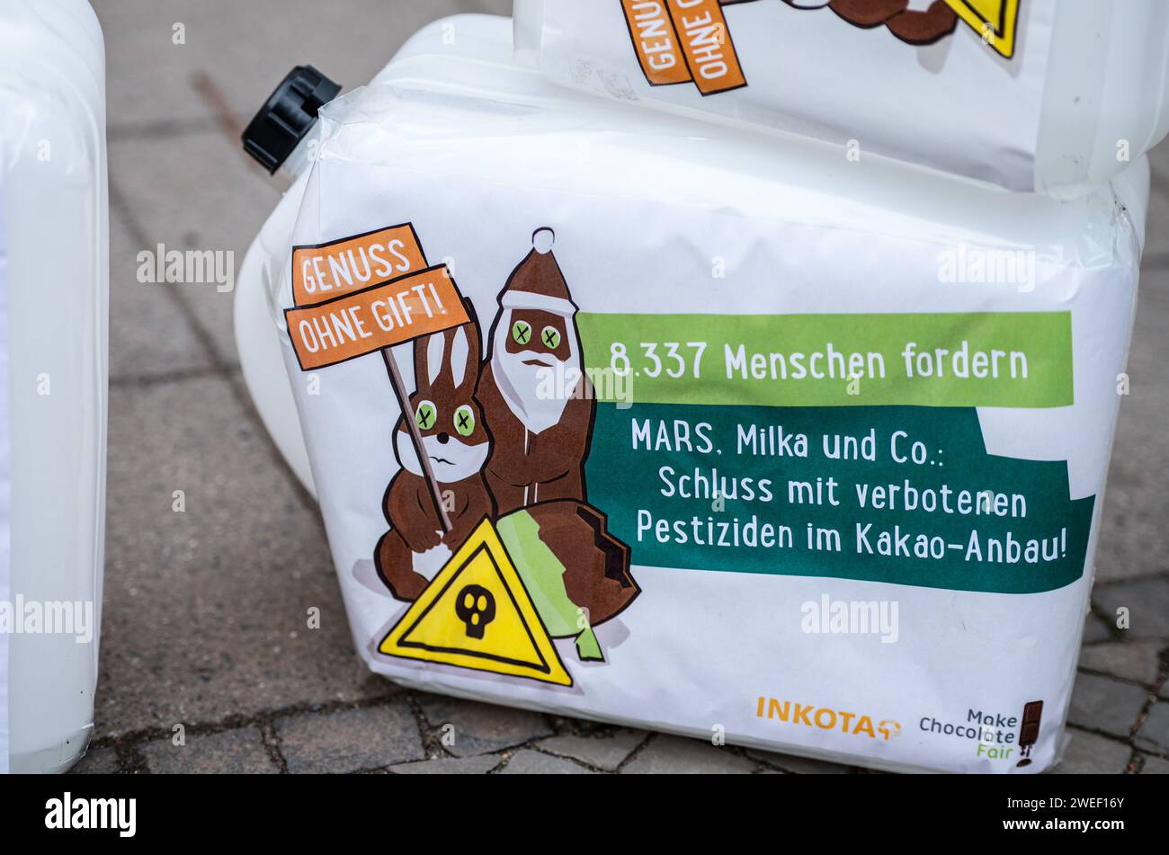 Deutschland, Berlin, 25. Januar 2024: Aktivistinnen und Aktivistinnen protestieren gegen den Einsatz hochgefährlicher Pestizide im Kakaoanbau im Vorfeld der ISM Cologne 2024 vor dem MARS M&M Store Berlin. Die Aktivisten und Unterstützer der Entwicklungsorganisation INKOTA-netzwerk e.V. fordern große Schokoladenunternehmen wie MARS AUF, den Einsatz hochgefährlicher Pestizide in ihren Lieferketten einzustellen, die in Europa aufgrund ihrer schädlichen Auswirkungen nicht zugelassen sind. Sie weisen darauf hin, dass 1,5 Millionen Kinder diesen Pestiziden in Kakaokulturen ausgesetzt sind Stockfoto