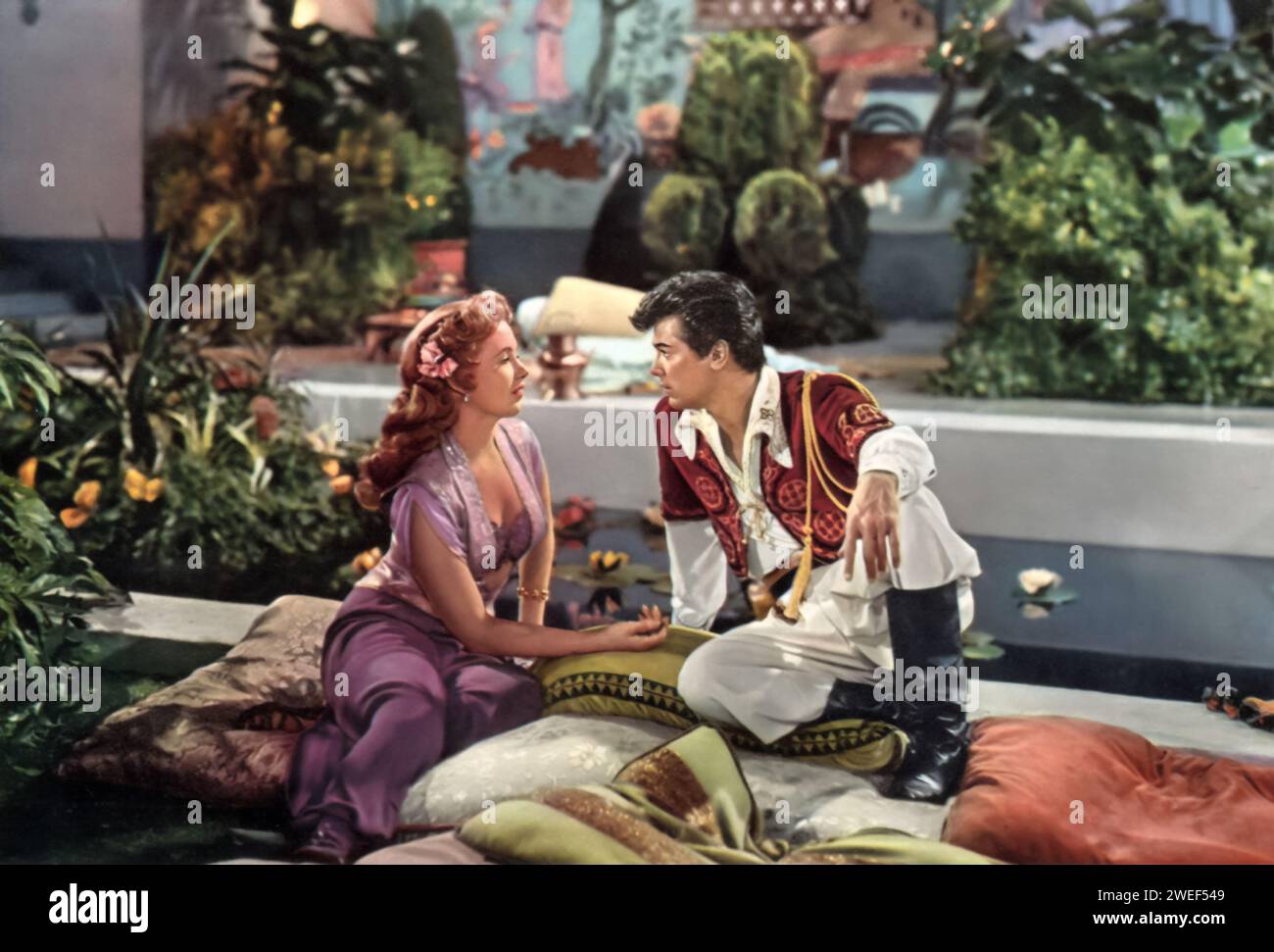 Ein Porträt von Piper Laurie und Tony Curtis mit dem Film Son of Ali Baba (1952). In diesem abenteuerlichen Film, der im alten Persien spielt, spielt Curtis Kashma Baba, den temperamentvollen und gewagten Sohn des legendären Ali Baba, während Laurie Prinzessin Azura darstellt, eine Figur, die willensstark und bezaubernd zugleich ist. Der Film ist bekannt für seine Mischung aus Romantik, Action und Curtis berühmter Zeile: „Dort liegt das Schloss meines Vaters“. Stockfoto