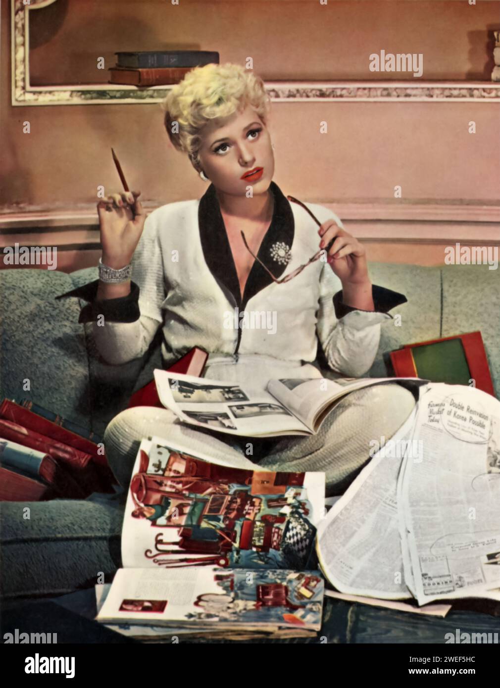 Die Schauspielerin Judy Holliday in einer Szene aus Born Yesterday (1950). In dieser klassischen romantischen Komödie spielt Holliday Billie Dawn, ein scheinbar unraffiniertes Ex-Chormädchen, das sich einer persönlichen Transformation unterzieht. Der Film verfolgt ihre Reise von der Naiveté zur Ermächtigung, hauptsächlich durch ihre Interaktionen mit einem Journalisten, gespielt von William Holden. Stockfoto