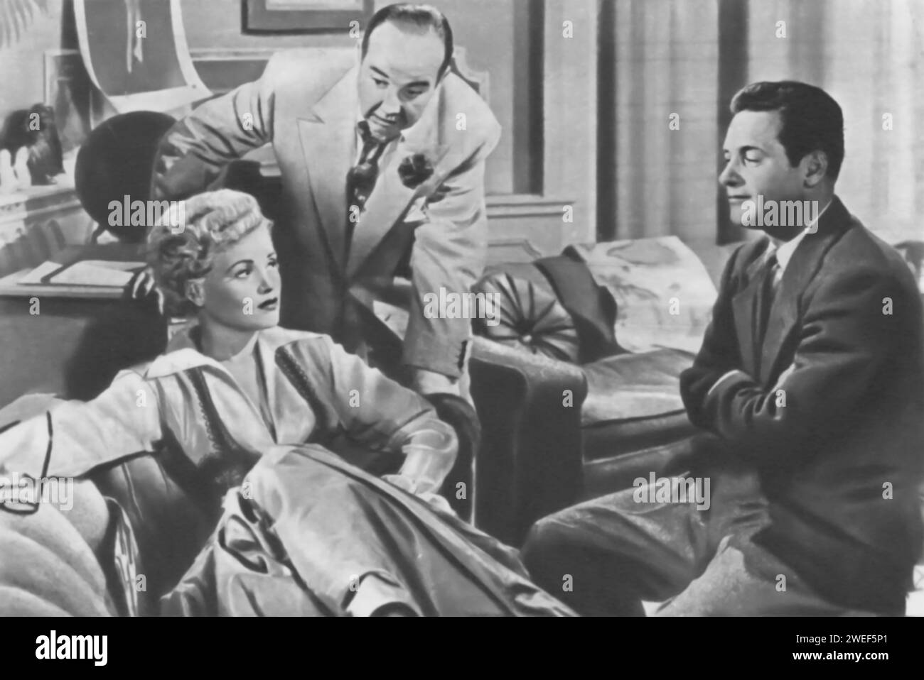 Judy Holliday, Broderick Crawford und William Holden sind die Hauptrollen in „Born Yesterday“ (1950). In diesem Film spielt Holliday Billie Dawn, die unraffinierte Freundin des korrupten Geschäftsmannes Harry Brock, dargestellt von Crawford. Holden tritt als Paul Verrall auf, ein Journalist, der Billie ausbilden soll. Die Geschichte folgt Billies Verwandlung von einer scheinbar naiven Frau zu einer unabhängigen Denkerin, beeinflusst durch ihre Lektionen bei Verrall. Stockfoto