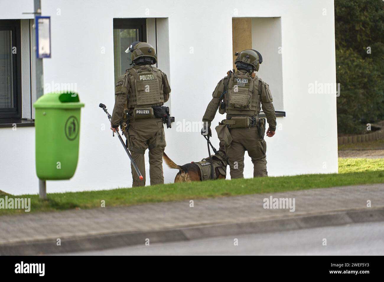 Montabaur, Deutschland. Januar 2024. Zwei SEK-Offiziere stehen kurz vor dem Angriff mit einem Hund vor einem Wohngebäude. Nach Angaben der Polizei wurden drei Menschen, darunter ein Kind, bei einem Akt der Gewalt in einem Wohngebiet getötet. Die Rettungsdienste entdeckten den mutmaßlichen Täter nach dem Betreten des Gebäudes schwer verletzt, so ein Polizeisprecher. Quelle: Sascha Ditscher/dpa/Alamy Live News Stockfoto