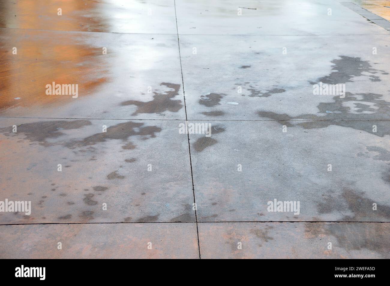 Nahaufnahme der Menschlichkeit auf dem Straßenboden. Nasser Boden durch Regen. Gefahrenunfall auf Gehsteig durch rutschiges Bodengefahrenkonzept. Stockfoto