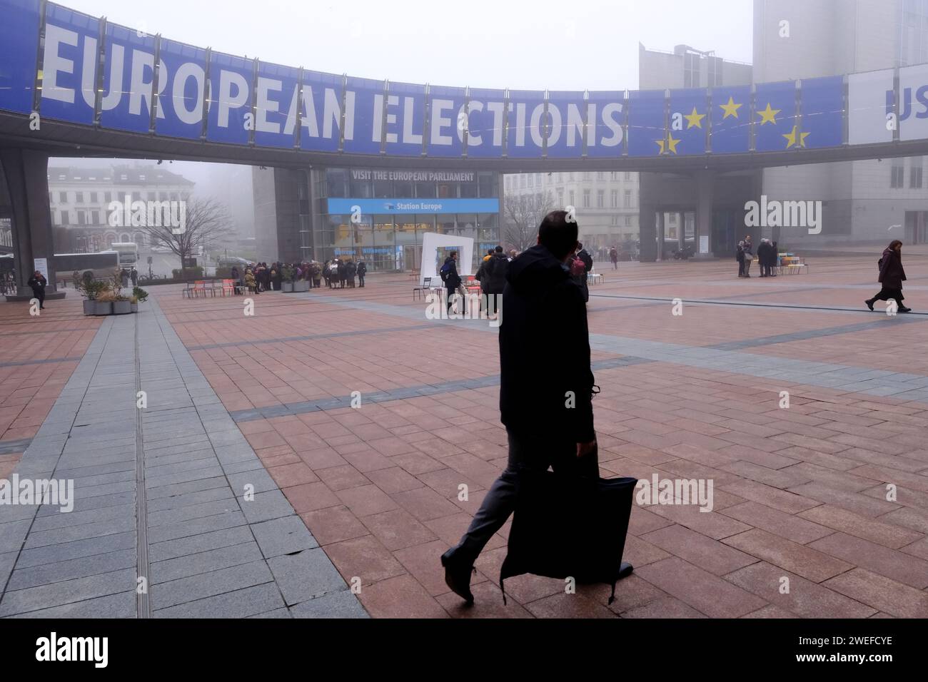 Brüssel, Belgien Januar 2024. Die Menschen laufen auf ein Banner zu, das die Europawahlen am 25. Januar 2023 vor dem Europäischen Parlament in Brüssel, Belgien, anzeigt. Quelle: ALEXANDROS MICHAILIDIS/Alamy Live News Stockfoto