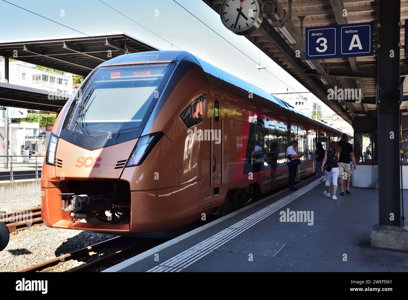 Eine Stadler FLIRT Traverso-Einheit der Südostbahn in der Schweiz steht am Bahnhof Locarno mit einem Zug nach Zürich. Stockfoto