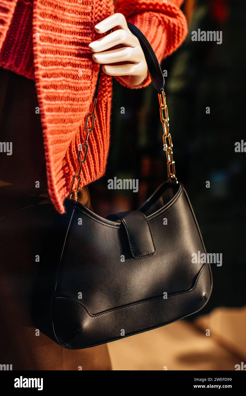 Klassische Damenhandtasche aus schwarzem Leder mit goldener Kette. Modische Details Stockfoto