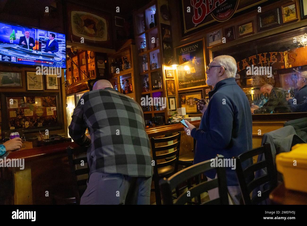 MANCHESTER, NEW HAMPSHIRE - 23. JANUAR: Die Patrons des Zigarrengeschäfts Castro's Back Room sehen die Erstaufführung von New Hampshire am 23. Januar 2024 in Manchester, New Hampshire. Der ehemalige Präsident Donald Trump gewann die Vorwahlen in New Hampshire gegen seinen einzigen verbleibenden großen Rivalen Nikki Haley, was ihn zum wahrscheinlichen republikanischen Kandidaten machte. In ihrer Rede nach der Wahl schwor Haley, im GOP-Rennen zu bleiben. (Foto: Michael Nigro) Stockfoto