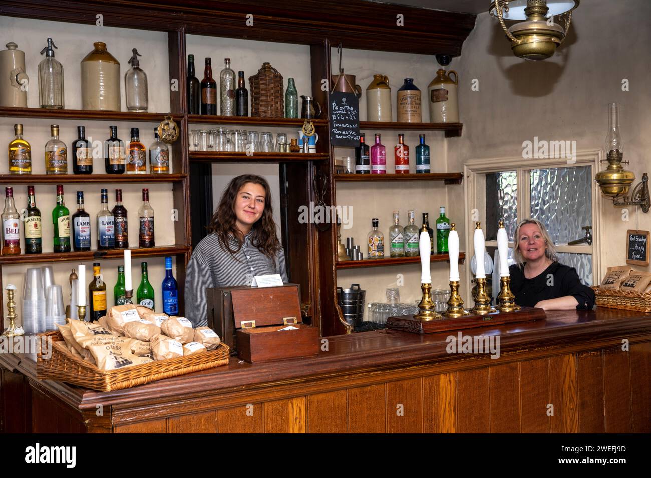 Großbritannien, England, West Midlands, Dudley, Black Country Museum, the Village, Personal hinter der 1900er Jahre Flasche und Glas Inn Bar Stockfoto