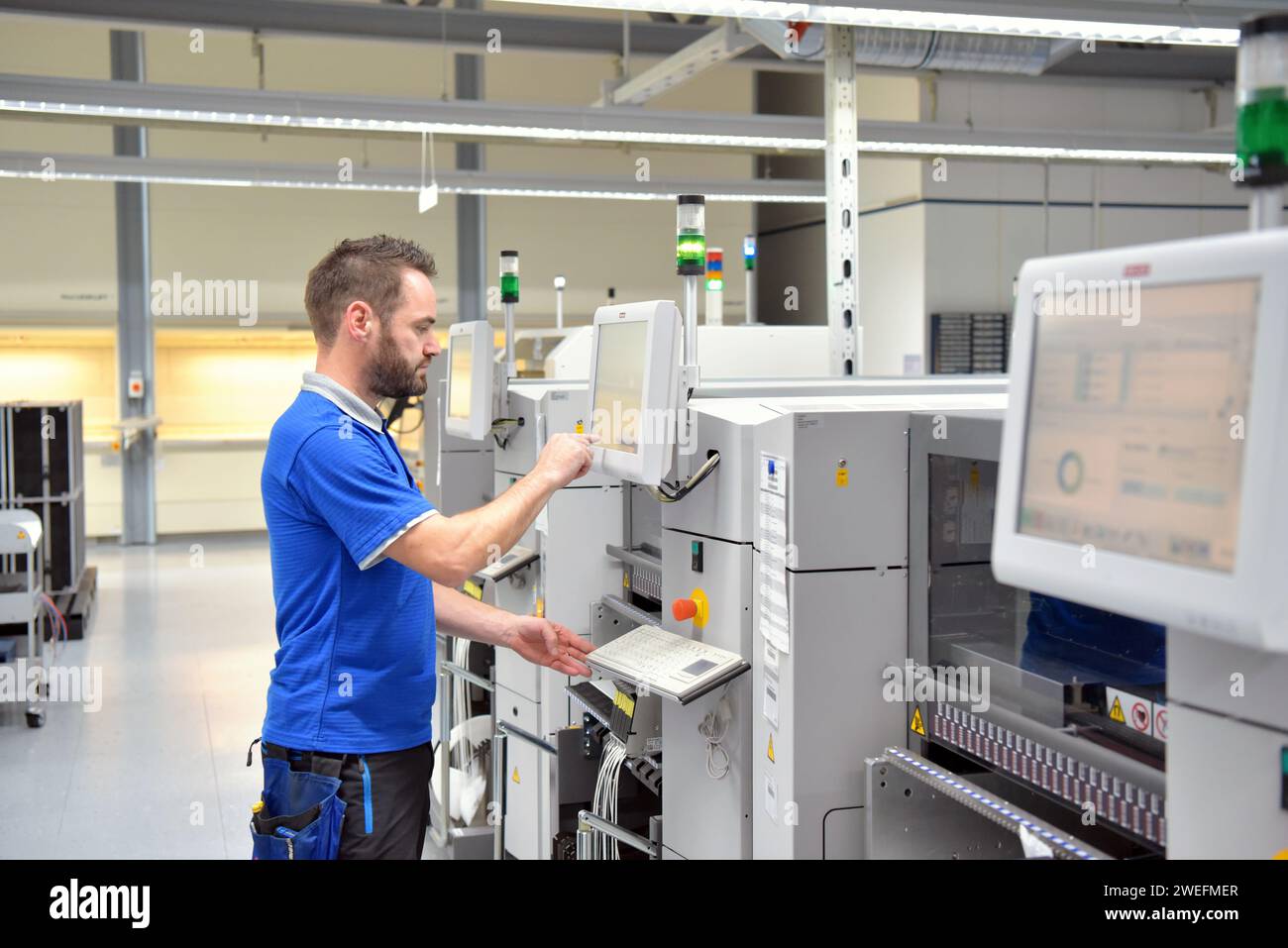 Engineering in der Mikroelektronik: Arbeiter in der Produktion und Montage von elektronischen High-Tech-Komponenten in ein modernes Werk Stockfoto