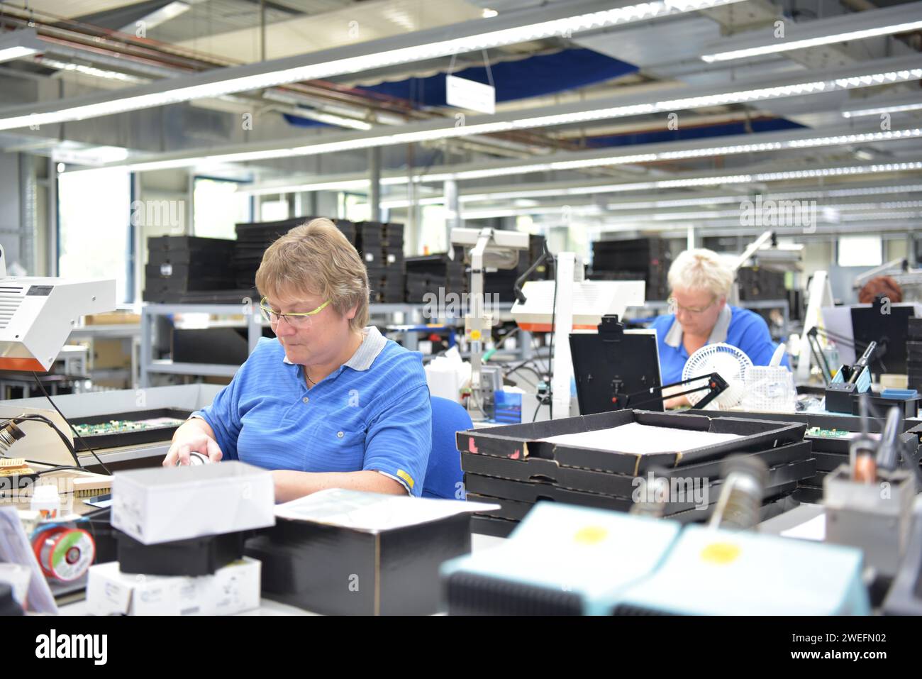 Freundliche Frau in einem mikroelektronikfertigung Factory-Komponenten Montage und Löten arbeiten Stockfoto