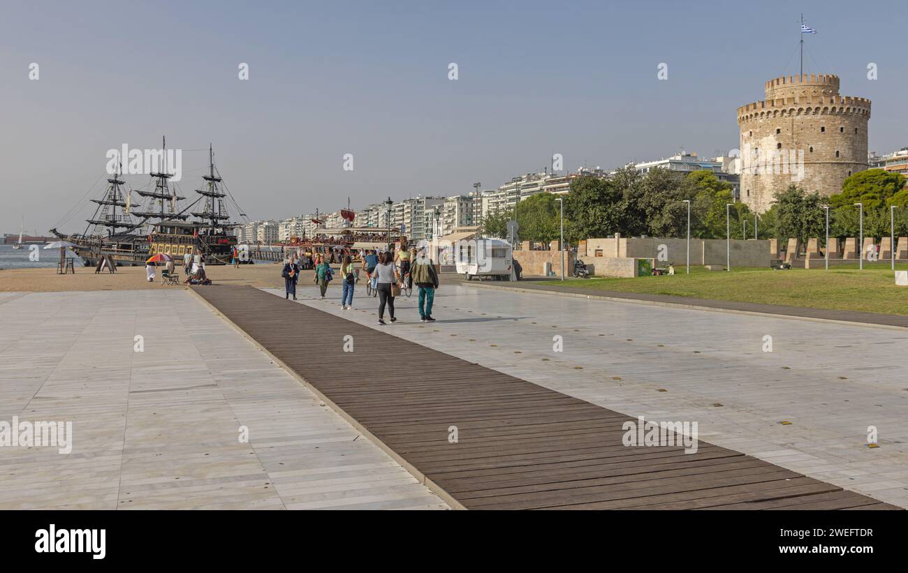 Thessaloniki, Griechenland - 22. Oktober 2023: Menschen gehen am Weißen Turm der Thessaloniki Square Promenade Historisches Wahrzeichen am sonnigen Herbsttag. Stockfoto