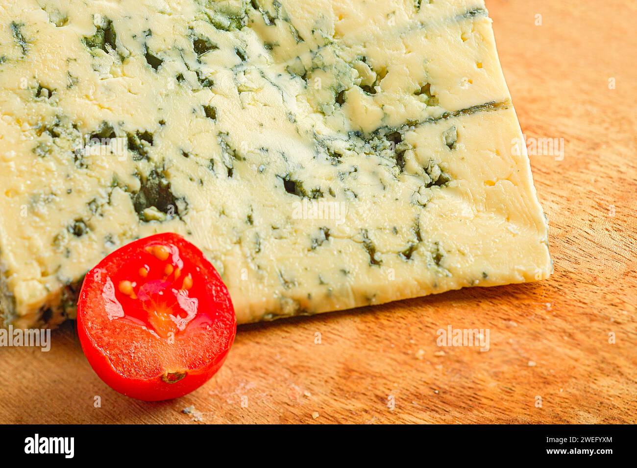 Eine Nahaufnahme von Roquefort Käse und Tomaten Arrangement auf einem Holzbrett Stockfoto