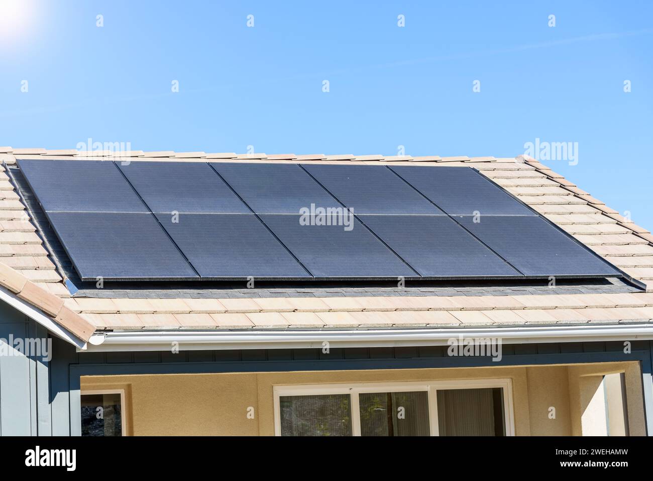 Solarpaneele, die das Dach eines neu errichteten energieeffizienten Hauses in einer Vorstadtentwicklung an einem sonnigen Herbsttag bedecken Stockfoto